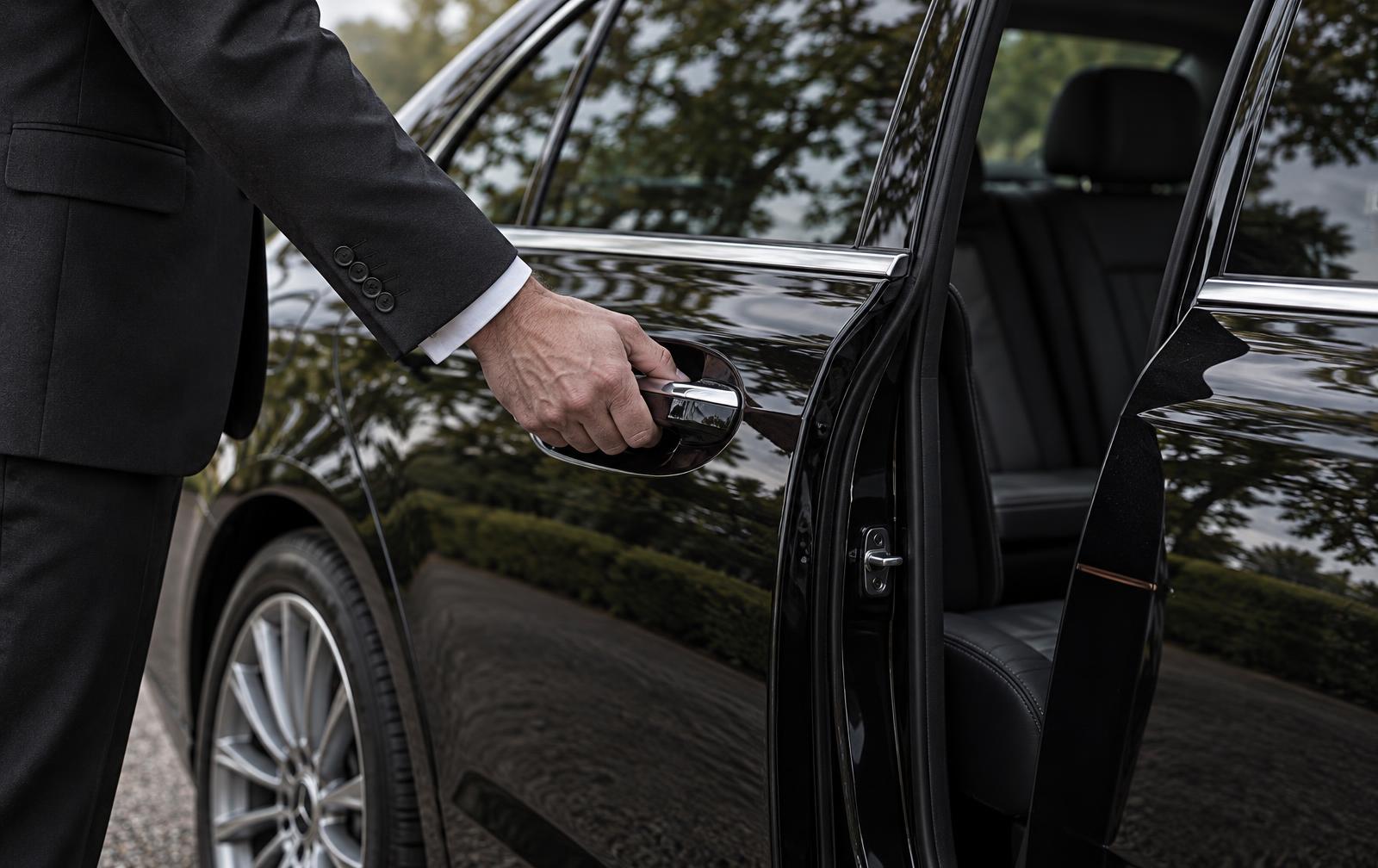Illustrative scene: Chauffeur opening an executive saloon's rear passenger door